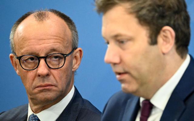 (FILES) German Chancellor Friedrich Merz (L) and German Finance Minister, Vice-Chancellor and leader of the Germany's Social Democratic Party (SPD) Lars Klingbeil attend a press briefing on the results of the coalition committee consultations on the pensions package, on November 28, 2025 at the Chancellery in Berlin. A year ago, German lawmakers elected conservative Friedrich Merz as chancellor. The chancellor had vowed to diminish the appeal of the country's far-right AfD party with two main strategies -- taking a tough stance on immigration to outflank the far-right party on the issue, and aiming to enact bold reforms to prove that centrist parties are still capable of acting. Tighter immigration rules have led to a significant decrease in arrivals -- but the chancellor does not appear to be benefitting political. Meanwhile the reform drive has stalled due to bickering between the conservative CDU and the social democratic SPD coalition parties, with the long-struggling economy making a slower than expected recovery. (Photo by Tobias SCHWARZ / AFP)