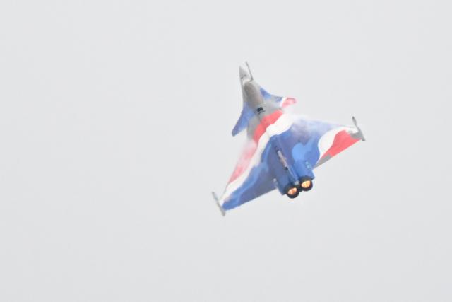 This photograph shows a Rafale Solo Display (RSD) aircraft, commanded by Captain Alexandre Roeckel, flying during the official presentation of the flight programme ahead of the start of the air show season at Nancy-Ochey air base 133 in Thuilley-aux-Groseilles on May 4, 2026. (Photo by Jean-Christophe VERHAEGEN / AFP)