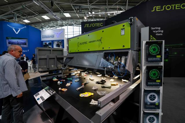 A visitor looks at the KI Varisort + flex machine by Sesotec on display at the IFAT Munich, a trade fair dedicated to environmental technologies across water, wastewater, waste and resource management, in Munich, southern Germany, on May 4, 2026. According to organisers, more than 3,000 exhibitors from more than 60 countries are presenting their strategies and innovations during the fair running until May 7, 2026. (Photo by Michaela STACHE / AFP)