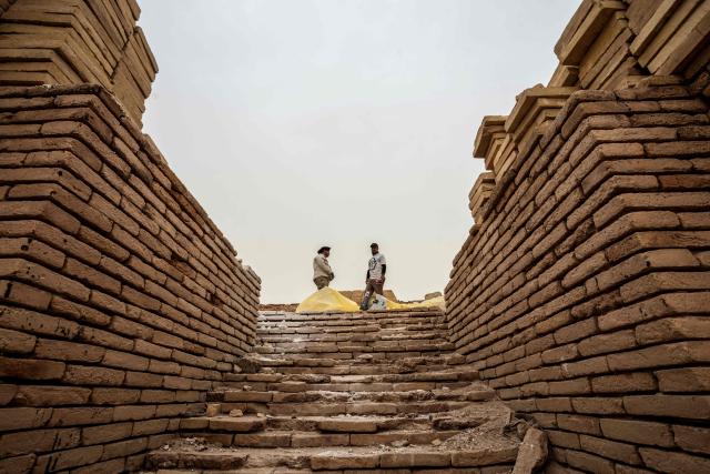 Members of the Iraqi Antiquities Authority maintenance team, work to restore the Great Ziggurat temple in the ancient city of Ur, believed to be the birthplace of Abraham, the patriarch of the worlds three monotheistic religions, located now in  Iraq's southern Dhi Qar province, some 16 kilometres from the centre of the city of Nasiriyah, on May 4, 2026. The ziggurat, one of several structures built by the ancient Sumerians in what is now modern-day Iraq, was believed to be the dwelling place of the gods. The temple at its summit was therefore off-limits to all but priests and other highly revered figures. Today, the Great Ziggurat is undergoing careful restoration, carried out by local craftsmen using regionally sourced materials, including bricks specially produced to match original ancient samples. (Photo by Assad NIYAZI / AFP)