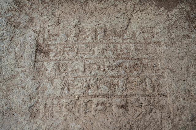 Cuneiform writing is pictured as a maintenance team from the Iraqi Antiquities Authority, works to restore the Great Ziggurat temple in the ancient city of Ur, believed to be the birthplace of Abraham, the patriarch of the worlds three monotheistic religions, located now in  Iraq's southern Dhi Qar province, some 16 kilometres from the centre of the city of Nasiriyah, on May 4, 2026. The ziggurat, one of several structures built by the ancient Sumerians in what is now modern-day Iraq, was believed to be the dwelling place of the gods. The temple at its summit was therefore off-limits to all but priests and other highly revered figures. Today, the Great Ziggurat is undergoing careful restoration, carried out by local craftsmen using regionally sourced materials, including bricks specially produced to match original ancient samples. (Photo by Assad NIYAZI / AFP)