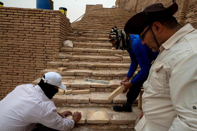 Members of the Iraqi Antiquities Authority maintenance team, works to restore the  sirs at the Great Ziggurat temple in the ancient city of Ur, believed to be the birthplace of Abraham, the patriarch of the worlds three monotheistic religions, located now in  Iraq's southern Dhi Qar province, some 16 kilometres from the centre of the city of Nasiriyah, on May 4, 2026. The ziggurat, one of several structures built by the ancient Sumerians in what is now modern-day Iraq, was believed to be the dwelling place of the gods. The temple at its summit was therefore off-limits to all but priests and other highly revered figures. Today, the Great Ziggurat is undergoing careful restoration, carried out by local craftsmen using regionally sourced materials, including bricks specially produced to match original ancient samples. (Photo by Assad NIYAZI / AFP)
