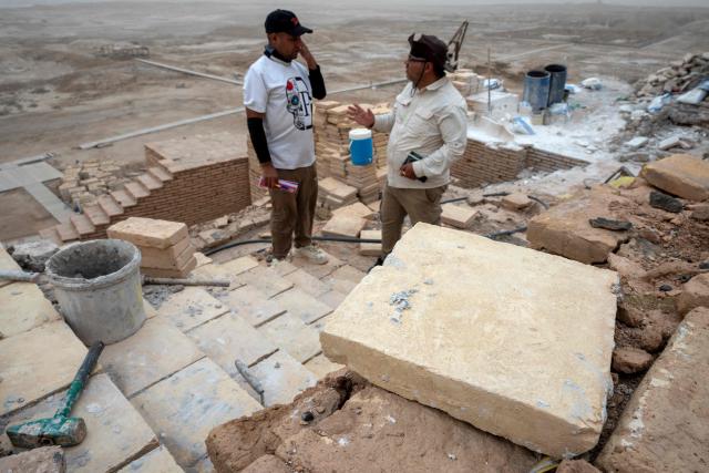Members the Iraqi Antiquities Authority maintenance team discus the restoration work of the Great Ziggurat temple in the ancient city of Ur, believed to be the birthplace of Abraham, the patriarch of the worlds three monotheistic religions, located now in  Iraq's southern Dhi Qar province, some 16 kilometres from the centre of the city of Nasiriyah, on May 4, 2026. The ziggurat, one of several structures built by the ancient Sumerians in what is now modern-day Iraq, was believed to be the dwelling place of the gods. The temple at its summit was therefore off-limits to all but priests and other highly revered figures. Today, the Great Ziggurat is undergoing careful restoration, carried out by local craftsmen using regionally sourced materials, including bricks specially produced to match original ancient samples. (Photo by Assad NIYAZI / AFP)