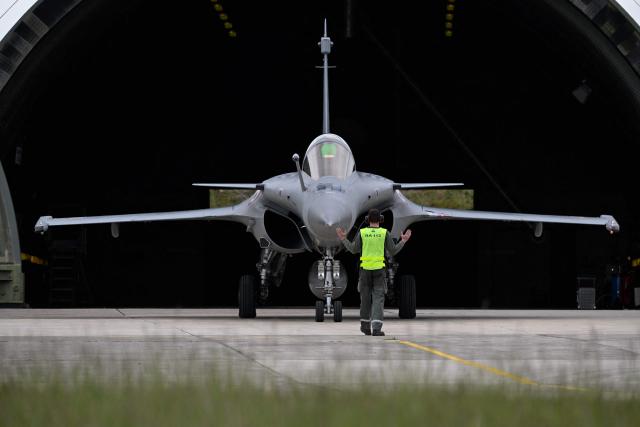 An aircraft mechanist guides a Rafale aircraft as part of the official presentation of the flight programme ahead of the start of the air show season at Nancy-Ochey air base 133 in Thuilley-aux-Groseilles on May 4, 2026.  (Photo by Jean-Christophe VERHAEGEN / AFP)