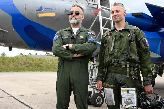 Captain Alexandre « Rocky » Roeckel (L), official pilot of the Rafale Solo Display (RSD) aircraft poses with his predecessor and coach Captain Jean-Brice « Mimouss » Millet as part of the official presentation of the flight programme ahead of the start of the air show season at Nancy-Ochey air base 133 in Thuilley-aux-Groseilles on May 4, 2026.  (Photo by Jean-Christophe VERHAEGEN / AFP)