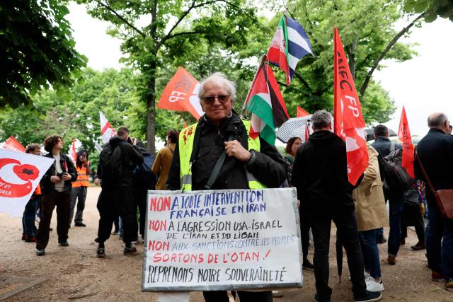 A demonstrator holds a anti NATO placard during a rally in front of the National Assembly to protest against the military spending bill, in Paris on May 4, 2026. (Photo by Xavier GALIANA / AFP)