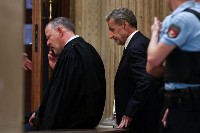 France's former President Nicolas Sarkozy leaves the courtroom during a break at his appeal trial over charges he had sought Libyan financing for his 2007 election in exchange for helping improve Tripoli's image after deadly bombing, at the Palais de Justice courthouse in Paris on May 4, 2026. (Photo by Anne-Christine POUJOULAT / AFP)