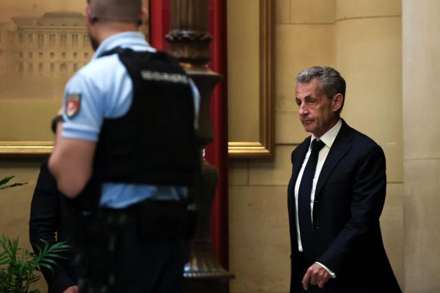 France's former President Nicolas Sarkozy leaves the courtroom during a break at his appeal trial over charges he had sought Libyan financing for his 2007 election in exchange for helping improve Tripoli's image after deadly bombing, at the Palais de Justice courthouse in Paris on May 4, 2026. (Photo by Anne-Christine POUJOULAT / AFP)
