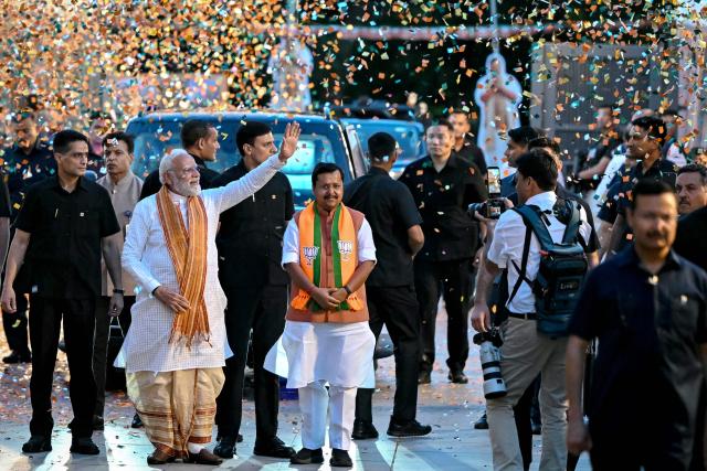India's Prime Minister and Bharatiya Janata Party (BJP) leader Narendra Modi (2L) waves to supporters as he arrives at party headquarters in New Delhi on May 4, 2026. Modi claimed victory on May 4 in state elections in opposition-held West Bengal, where his party has never been in power before. (Photo by Sajjad HUSSAIN / AFP)