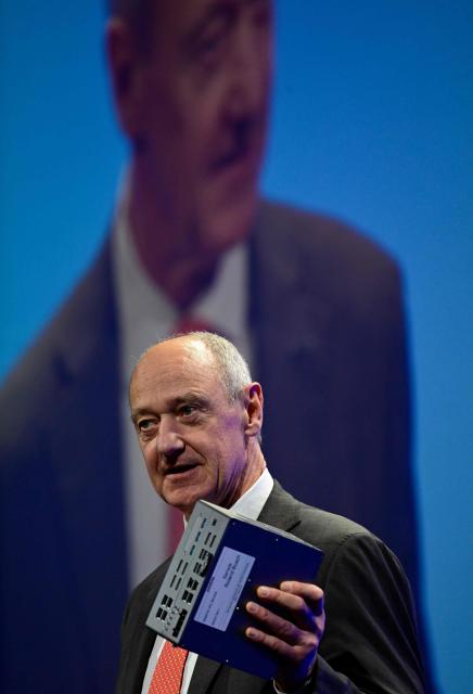 Siemens CEO Roland Busch holds a Siemens computer with a NVIDIA chip as he addresses guests during the economic policy summit (Wirtschaftstag) in Berlin on May 4, 2026. The two-day summit brings together key players from politics and business. (Photo by John MACDOUGALL / AFP)