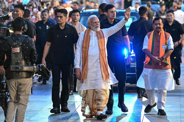 India's Prime Minister and Bharatiya Janata Party (BJP) leader Narendra Modi (C) waves to supporters as he arrives at party headquarters in New Delhi on May 4, 2026. Modi claimed victory on May 4 in state elections in opposition-held West Bengal, where his party has never been in power before. (Photo by Sajjad HUSSAIN / AFP)