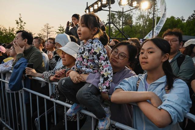 People watch a free music concert in a park in Beijing on May 4, 2026, the fourth day of a five-day national May Day holiday. (Photo by GREG BAKER / AFP)