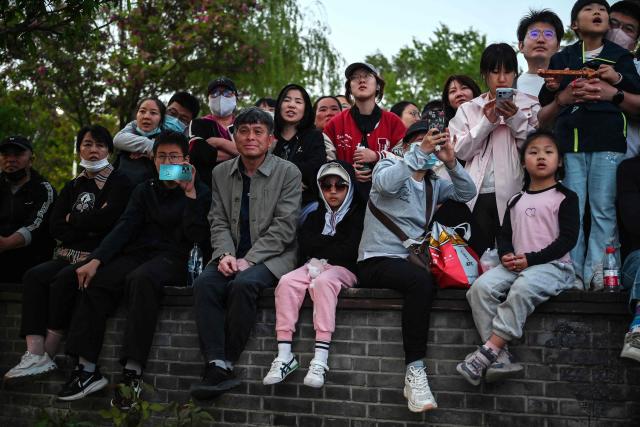 People watch a free music concert in a park in Beijing on May 4, 2026, the fourth day of a five-day national May Day holiday. (Photo by GREG BAKER / AFP)