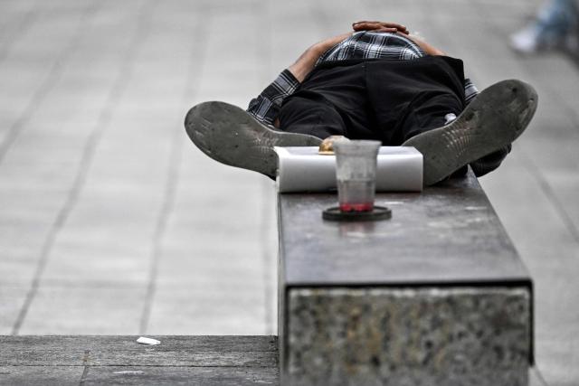 A homeless person sleeps at a parapet in the city of Frankfurt am Main, western Germany, on May 4, 2026. (Photo by Kirill KUDRYAVTSEV / AFP)