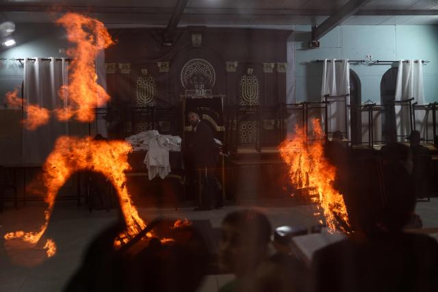 Bonfires are reflected on windows as Ultra-Orthodox Jews celebrate Lag BaOmer in Jerusalem on May 4, 2026. Lag BaOmer marks the anniversary of the death of Talmudic sage Rabbi Shimon Bar Yochai approximately 1,900 years ago. (Photo by Ilia YEFIMOVICH / AFP)