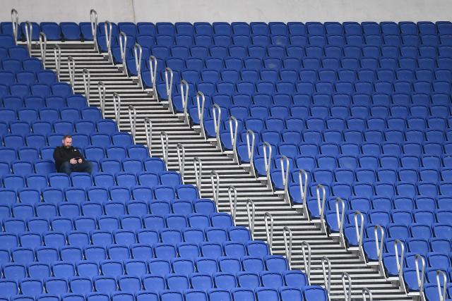 A man is pictured in the empty stands ahead of the English Premier League football match between Everton and Manchester City at Hill Dickinson Stadium in Liverpool on May 4, 2026. (Photo by PETER POWELL / AFP)