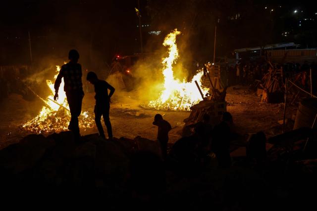 People gather around a bonfire as ultra-Orthodox Jews celebrate Lag BaOmer in Jerusalem on May 4, 2026. Lag BaOmer marks the anniversary of the death of Talmudic sage Rabbi Shimon Bar Yochai approximately 1,900 years ago. (Photo by Ilia YEFIMOVICH / AFP)