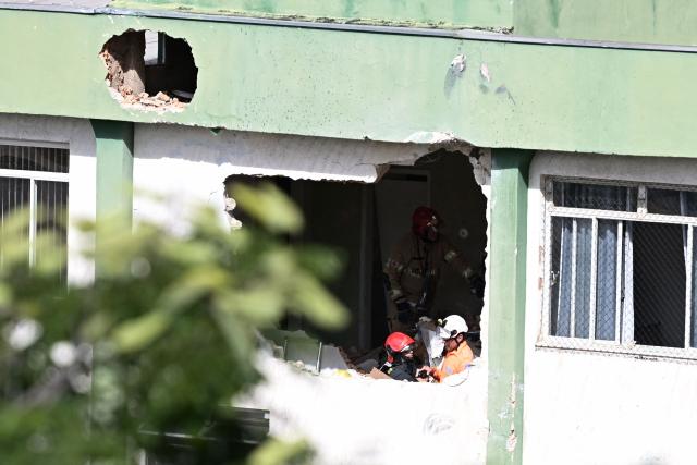 Firefighters inspect the area of the wreckage of a small plane that crashed into a building in downtown Belo Horizonte, Minas Gerais state, Brazil, on May 4, 2026. A small plane crashed into the side of a building in the southeastern city of Belo Horizonte on May 4, killing the pilot and copilot, firefighters said. (Photo by GLEDSTON TAVARES / AFP)