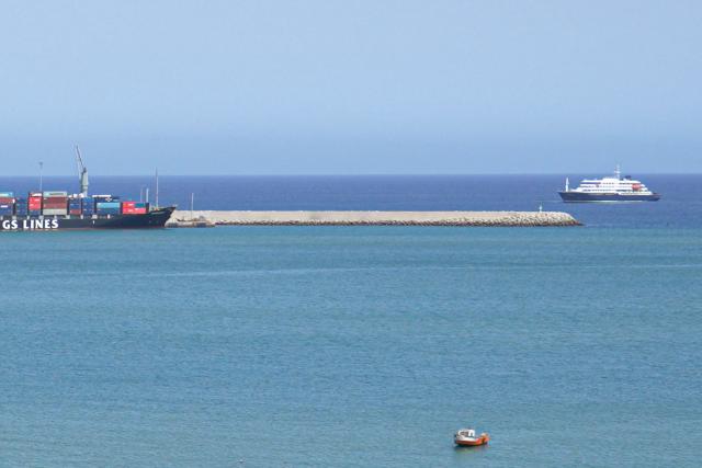 A general view of the cruise ship MV Hondius (R) stationary off the port of Praia, the capital of Cape Verde, on May 4, 2026. Strict precautionary measures including isolation are in place on a cruise ship anchored off Cape Verde on which a suspected outbreak of hantavirus has killed three people, the cruise operator said on May 4, 2026.
The Canary Islands are being "considered" for disembarkation of the boat, which has 149 people of 23 nationalities on board, after Cape Verde refused entry, Oceanwide Expeditions said in a statement. (Photo by AFP)