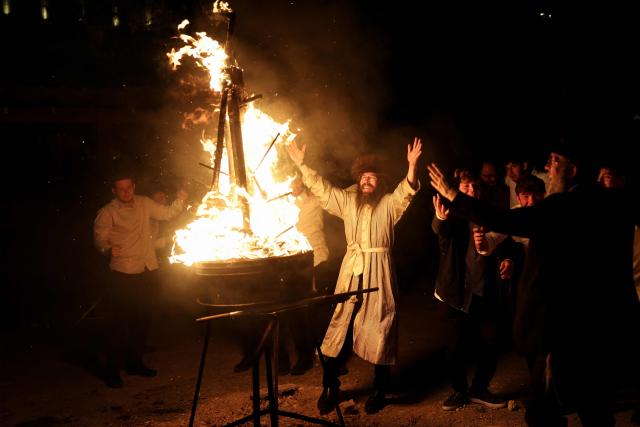 Ultra-Orthodox Jewish men dance around a fire the Mea Shearim neighbourhood as they celebrate the Jewish holiday of Lag BaOmer in Jerusalem on May 4, 2026. Lag BaOmer marks the anniversary of the death of Talmudic sage Rabbi Shimon Bar Yochai approximately 1,900 years ago. (Photo by Ilia YEFIMOVICH / AFP)