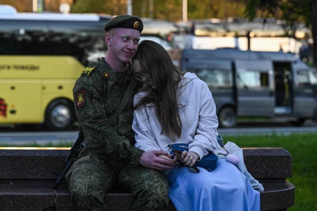 Russian serviceman hugs a girl before the rehearsal of the Victory Day military parade, to be held at Red Square, in central Moscow on May 4, 2026. Russia declared on May 4 a unilateral ceasefire with Ukraine between May 8-9, when Moscow marks its annual World War II Victory Day commemorations, and threatened a "massive missile strike" on Kyiv if Ukraine violated it. (Photo by Igor IVANKO / AFP)