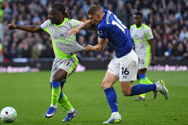 Manchester City's Belgian midfielder #11 Jeremy Doku (L) fights for the ball with Everton's Ukrainian defender #16 Vitaliy Mykolenko (R) during the Premier League football match between Everton and Manchester City at the Hill Dickinson Stadium in Liverpool on May 4, 2026. (Photo by PETER POWELL / AFP)