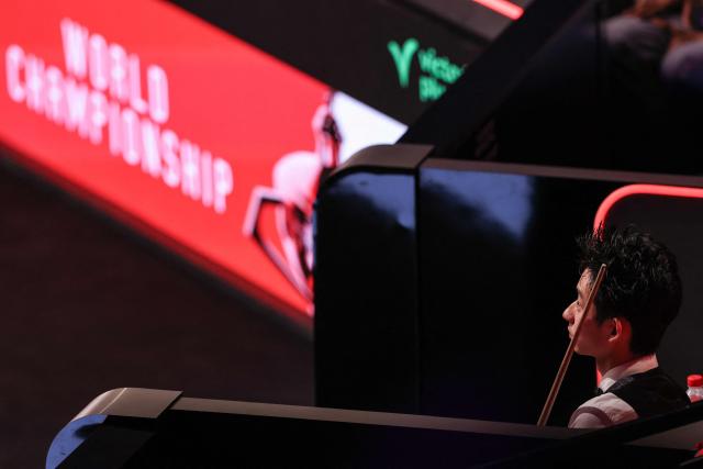 China's Wu Yize (R) waits for his turn to play against England's Shaun Murphy during the World Snooker Championship final round at The Crucible in Sheffield, northern England on May 4, 2026. (Photo by Darren Staples / AFP)