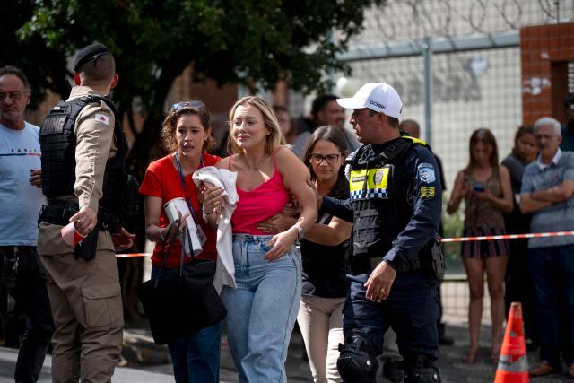 A resident of the area where a small plane crashed into a building receives help in downtown Belo Horizonte, Minas Gerais state, Brazil, on May 4, 2026. A small plane crashed into the side of a building in the southeastern city of Belo Horizonte on May 4, killing the pilot and copilot, firefighters said. (Photo by GLEDSTON TAVARES / AFP)
