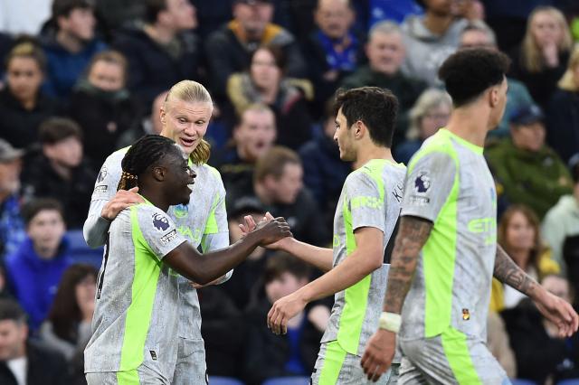 Manchester City's Belgian midfielder #11 Jeremy Doku (L) celebrates with teammates after scoring the opening goal during the English Premier League football match between Everton and Manchester City at Hill Dickinson Stadium in Liverpool on May 4, 2026. (Photo by PETER POWELL / AFP)