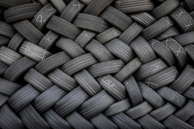 This photograph shows a stack of used tires in a garage in Orbe, Switzerland on May 1, 2026. (Photo by Fabrice COFFRINI / AFP)