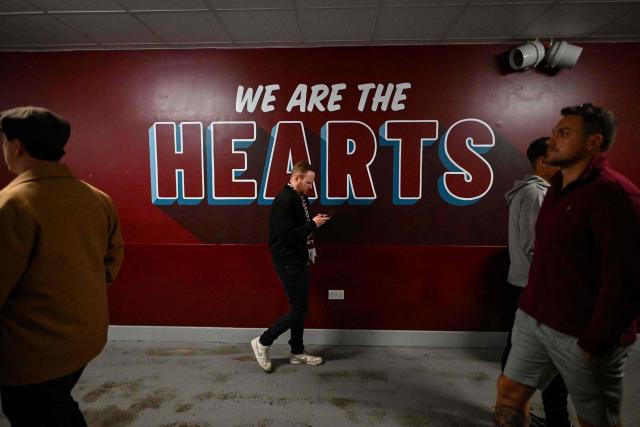 A Hearts fan walks past a slogon painted on the wall during the Scottish Premiership football match between Hearts and Rangers at Tynecastle Stadium in Edinburgh on May 4, 2026. Hearts are hoping to become the first club other than Celtic and Rangers to win the Scottish crown since Aberdeen in 1985. (Photo by ANDY BUCHANAN / AFP)