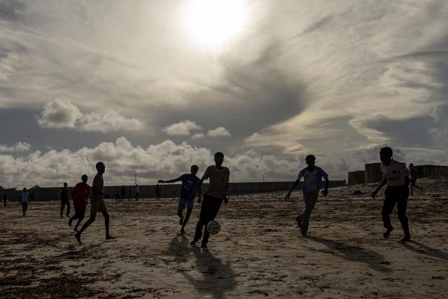 Young Somali boys play football on the beach in Kismayo on April 22, 2026. Millions of people in Somalia are facing the repercussions of a severe drought after three consecutive failed raining seasons. Kismayo, the capital of Jubaland State in southern Somalia, is one of the largest IDP-receiving cities in the Horn of Africa country, receiving hundreds of thousands of people fleeing the prolonged drought and conflict. Save the Children provides health and nutrition services in the region. (Photo by SIMON MAINA / AFP)