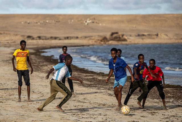 Young Somali boys play football on the beach in Kismayo on April 22, 2026. Millions of people in Somalia are facing the repercussions of a severe drought after three consecutive failed raining seasons. Kismayo, the capital of Jubaland State in southern Somalia, is one of the largest IDP-receiving cities in the Horn of Africa country, receiving hundreds of thousands of people fleeing the prolonged drought and conflict. Save the Children provides health and nutrition services in the region. (Photo by SIMON MAINA / AFP)