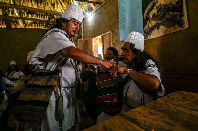 Arhuaco Governor Luis Salcedo Zalabata is welcomed at the Kutunsama Indigenous Reservation in Tayrona National Natural Park, Magdalena department, Colombia, on April 18, 2026. At first glance, it appears to be a postcard-perfect tourist jewel, with crystal-clear Caribbean waters and mountains crowned by snowcapped peaks. But beneath the surface of Colombias idyllic destination, paramilitary violence keeps shopkeepers and Indigenous communities living in fear. In the Sierra Nevada de Santa Marta, tourists roam unaware of camouflaged squads monitoring them from close range, extorting nearby businesses and spreading terror among Indigenous communities, whose ancestral knowledge has been recognized by UNESCO as part of the worlds cultural heritage. (Photo by Luis ACOSTA / AFP)