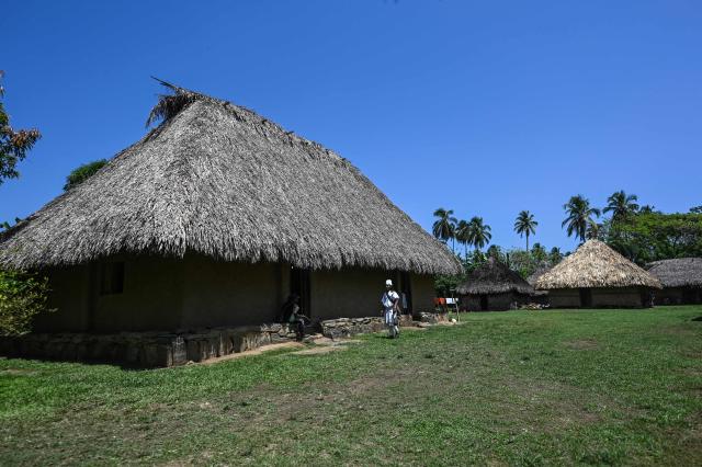 An Arhuaco Indigenous man walks at the Kutunsama Indigenous Reservation in Tayrona National Natural Park, Magdalena department, Colombia, on April 18, 2026. At first glance, it appears to be a postcard-perfect tourist jewel, with crystal-clear Caribbean waters and mountains crowned by snowcapped peaks. But beneath the surface of Colombias idyllic destination, paramilitary violence keeps shopkeepers and Indigenous communities living in fear. In the Sierra Nevada de Santa Marta, tourists roam unaware of camouflaged squads monitoring them from close range, extorting nearby businesses and spreading terror among Indigenous communities, whose ancestral knowledge has been recognized by UNESCO as part of the worlds cultural heritage. (Photo by Luis ACOSTA / AFP)