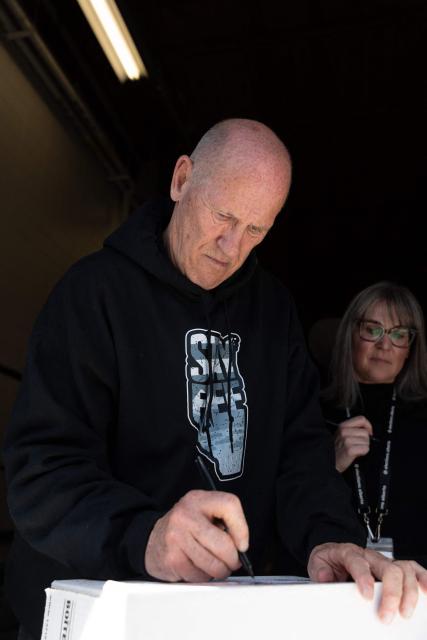 Separatist leader Mitch Sylvestre is seen during a rally in front of the Elections Alberta headquarters in Edmonton, Canada, on May 4, 2026, as they submit boxes of signatures in the hope of triggering an independence referendum. Alberta separatists submitted stacks of boxes to election officials on Monday, which they said contained the signatures of more than 300,000 supporters, enough names to force an independence referendum in Canada's oil-rich province. A boisterous crowd of several hundred waved the blue provincial flag on a bright, clear day, cheering as separatist leader Mitch Sylvestre delivered the petitions to Elections Alberta. (Photo by Henry MARKEN / AFP)