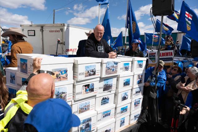 Separatist leader Mitch Sylvestre is seen during a rally in front of the Elections Alberta headquarters in Edmonton, Canada, on May 4, 2026, as they submit boxes of signatures in the hope of triggering an independence referendum. Alberta separatists submitted stacks of boxes to election officials on Monday, which they said contained the signatures of more than 300,000 supporters, enough names to force an independence referendum in Canada's oil-rich province. A boisterous crowd of several hundred waved the blue provincial flag on a bright, clear day, cheering as separatist leader Mitch Sylvestre delivered the petitions to Elections Alberta. (Photo by Henry MARKEN / AFP)