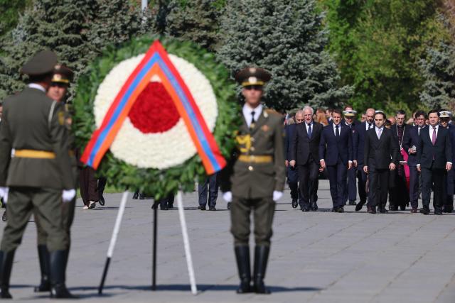 France's President Emmanuel Macron, Armenia's President Vahagn Khachaturyan and officials arrive at the Tsitsernakaberd Armenian Genocide Memorial in Yerevan on May 5, 2026. (Photo by Ludovic MARIN / AFP)