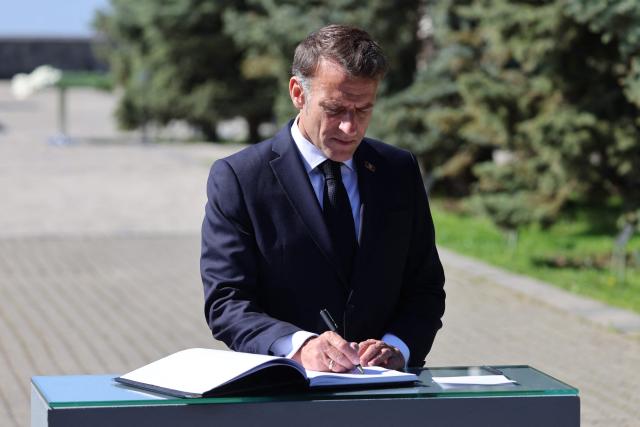 France's President Emmanuel Macron signs the guests book while visiting the Tsitsernakaberd Armenian Genocide Memorial in Yerevan on May 5, 2026. (Photo by Ludovic MARIN / AFP)