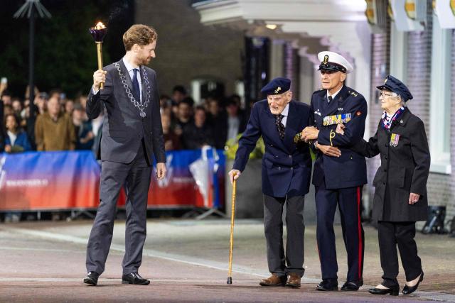 British Veteran Robbie Hall, 103, and Dutch Veteran Johan Geneuglijk, 105, together with Wageningen's Mayor Floor Vermeulen, light the Liberation Fire during the Liberation Fire ceremony in Wageningen on May 5, 2026. The ceremony symbolizes the transition from commemorating the WWII to celebrating the Netherlands’ liberation from the German occupier. (Photo by Vincent Jannink / ANP / AFP) / Netherlands OUT