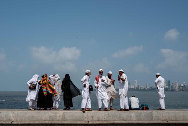 A family enjoys the view from a sea front in Mumbai on May 5, 2026. (Photo by Punit PARANJPE / AFP)