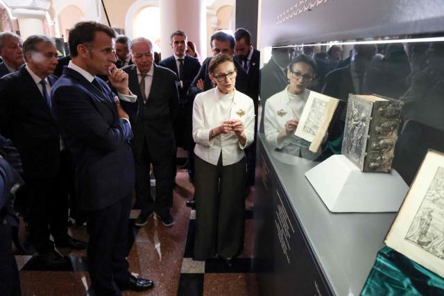 France's President Emmanuel Macron looks at the first Armenian language printed Bible as he visits the Matenadaran museum, Armenia's cultural institution which houses the vast collection of ancient manuscripts, in Yerevan on May 5, 2026. (Photo by Ludovic MARIN / AFP)
