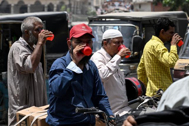 People enjoy a chilled refreshment along a street on a hot summer day in Karachi on May 5, 2026. (Photo by Rizwan TABASSUM / AFP)