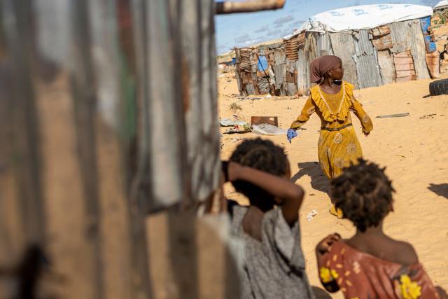 Somali internally displaced children play near their makeshift shelters at a internally displaced persons (IDP) camo in Ceel Cad, Kismayo town, on April 20, 2026. Millions of people in Somalia are facing the repercussions of a severe drought after three consecutive failed raining seasons.  Kismayo, the capital of Jubaland State in southern Somalia, is one of the largest IDP-receiving cities in the Horn of Africa country, receiving hundreds of thousands of people fleeing the prolonged drought and conflict. (Photo by SIMON MAINA / AFP)