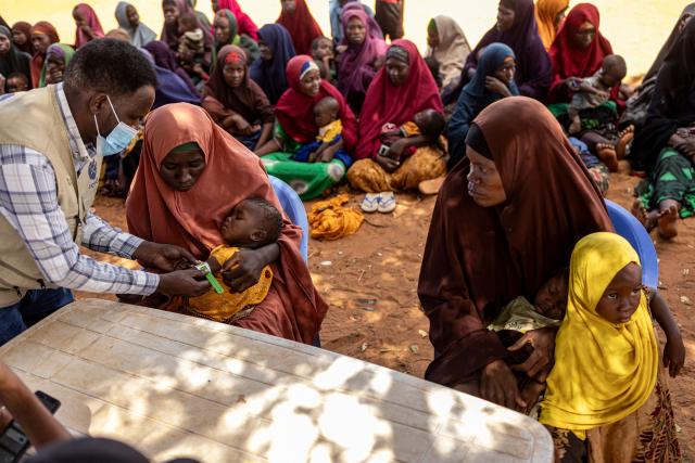 Newly arrived Somali women register as their children are screened for malnutrition at an internally displaced persons (IDP) camp in the outskirts of Kismayo town, on April 21, 2026. Millions of people in Somalia are facing the repercussions of a severe drought after three consecutive failed raining seasons. Kismayo, the capital of Jubaland State in southern Somalia, is one of the largest IDP-receiving cities in the Horn of Africa country, receiving hundreds of thousands of people fleeing the prolonged drought and conflict. Save the Children provides health and nutrition services across the camp. (Photo by SIMON MAINA / AFP)