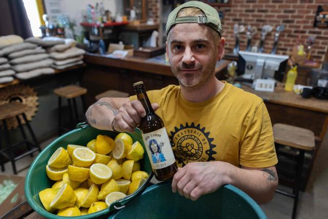 French brewer Aurelien Picard holds a bottle of a beer named 'John Lemon', a play on words in reference to British musician John Lennon at the brewery 'Brasserie de l'imprimerie' in Bannalec, western France on May 5, 2026. Following a formal notice from Yoko Ono, the widow of the Beatles singer, a Breton brewery has sold several thousand bottles of ‘John Lemon’ beer in just a few days – beer it will no longer be able to sell after July 1, 2026, the brewer told AFP on May 5, 2026. At the end of March, a Dutch law firm served the brewery with a formal notice to cease marketing ‘John Lemon’, failing which it would face having to pay substantial sums to the Yoko Ono Trust, which is responsible for protecting John Lennon’s image. (Photo by Fred TANNEAU / AFP)