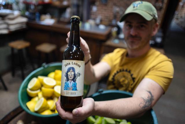 French brewer Aurelien Picard holds a bottle of a beer named 'John Lemon', a play on words in reference to British musician John Lennon at the brewery 'Brasserie de l'imprimerie' in Bannalec, western France on May 5, 2026. Following a formal notice from Yoko Ono, the widow of the Beatles singer, a Breton brewery has sold several thousand bottles of ‘John Lemon’ beer in just a few days – beer it will no longer be able to sell after July 1, 2026, the brewer told AFP on May 5, 2026. At the end of March, a Dutch law firm served the brewery with a formal notice to cease marketing ‘John Lemon’, failing which it would face having to pay substantial sums to the Yoko Ono Trust, which is responsible for protecting John Lennon’s image. (Photo by Fred TANNEAU / AFP)