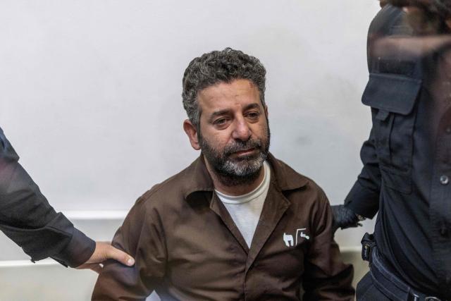 Israeli officers bring Spanish activist Saif Abu Keshek to a court in Ashkelon on May 5, 2026. Two foreign activists from a Gaza-bound flotilla who have been detained in Israeli prison are facing psychological abuse, death threats and poor detention conditions, a rights group representing them said on May 4. The pair were among dozens of activists aboard a Gaza-bound flotilla intercepted by Israeli forces off the coast of Greece early on April 30. (Photo by ilia YEFIMOVICH / AFP)