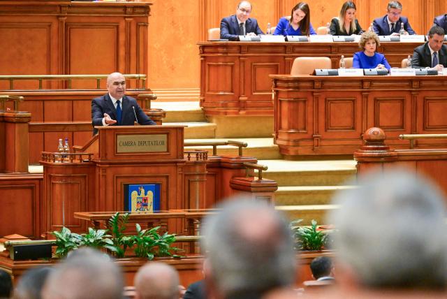 Romanian Prime Minister Ilie Bolojan addresses the Parliament in Bucharest on May 5, 2026. Romania's parliament on May 5 will vote on a motion of no confidence that could oust Premier Bolojan, deepening political turmoil in the country, an EU and NATO member bordering Ukraine. Romania's biggest party, the Social Democrats (PSD), quit the government last month and joined forces with the far right to file the motion. (Photo by Daniel MIHAILESCU / AFP)