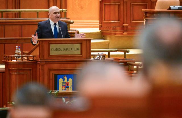 Romanian Prime Minister Ilie Bolojan addresses the Parliament in Bucharest on May 5, 2026. Romania's parliament on May 5 will vote on a motion of no confidence that could oust Premier Bolojan, deepening political turmoil in the country, an EU and NATO member bordering Ukraine. Romania's biggest party, the Social Democrats (PSD), quit the government last month and joined forces with the far right to file the motion. (Photo by Daniel MIHAILESCU / AFP)
